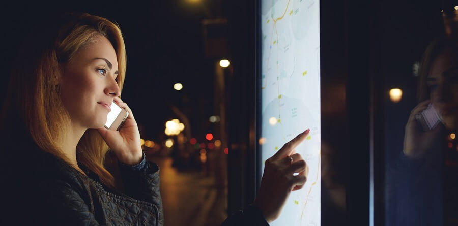 A woman using wayfinding services on a touchscreen. Interactive content of this kind is incredibly popular.