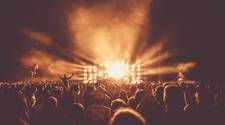 A nighttime concert scene. An incredibly bright light illuminates the crowd