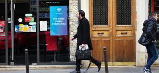 <p>A man walking by a digital display operated by Turnadon in France</p>
