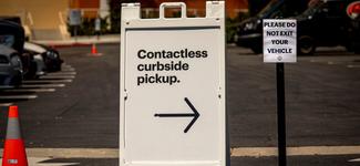 <p>A white sign indicating where customers can go to do curbside pickup for online orders</p>
