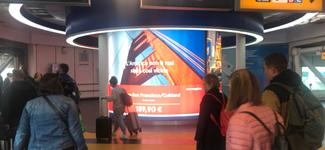 <p>A huge indoor display at an airport, owned by Media One. Passengers are walking in front of it.</p>
