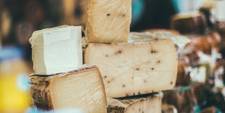 A stack of different cheeses, all in plastic wrap.