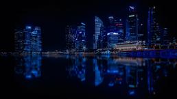 <p>A city in the dark of night, lit up lights in and around its buildings.</p>